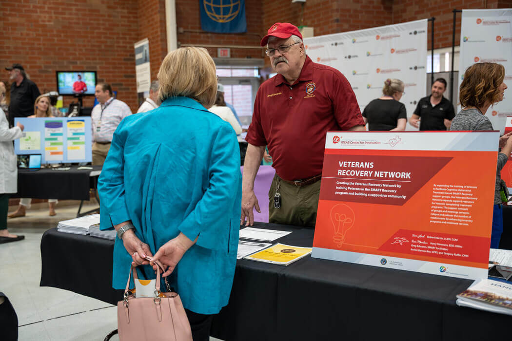 Man from IDEAS talking to woman at conference