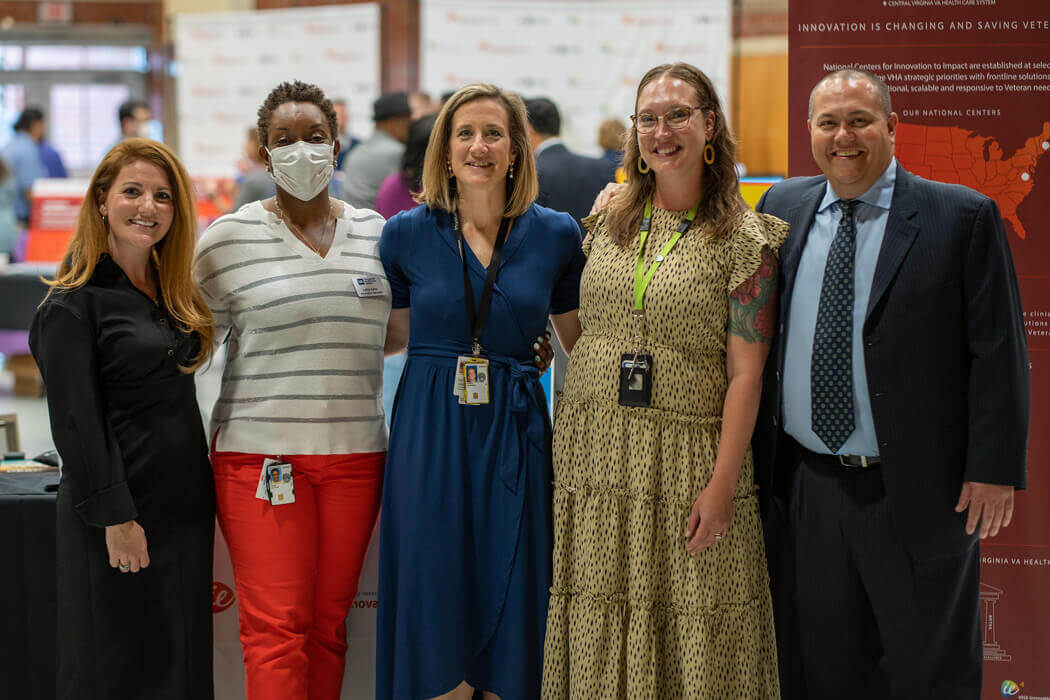 Small group of men and women posing for photo at conference