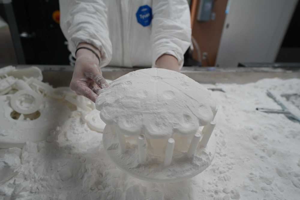 A person placing two 3d printed makeup brush holder pieces together